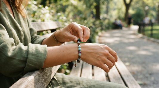 Adjusting a bead bracelet on a park bench