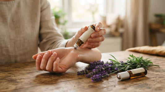 Applying a lavender roll-on to the wrist next to fresh lavender sprigs