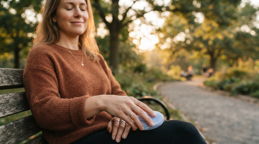 A woman on a park bench holding a smooth worry stone