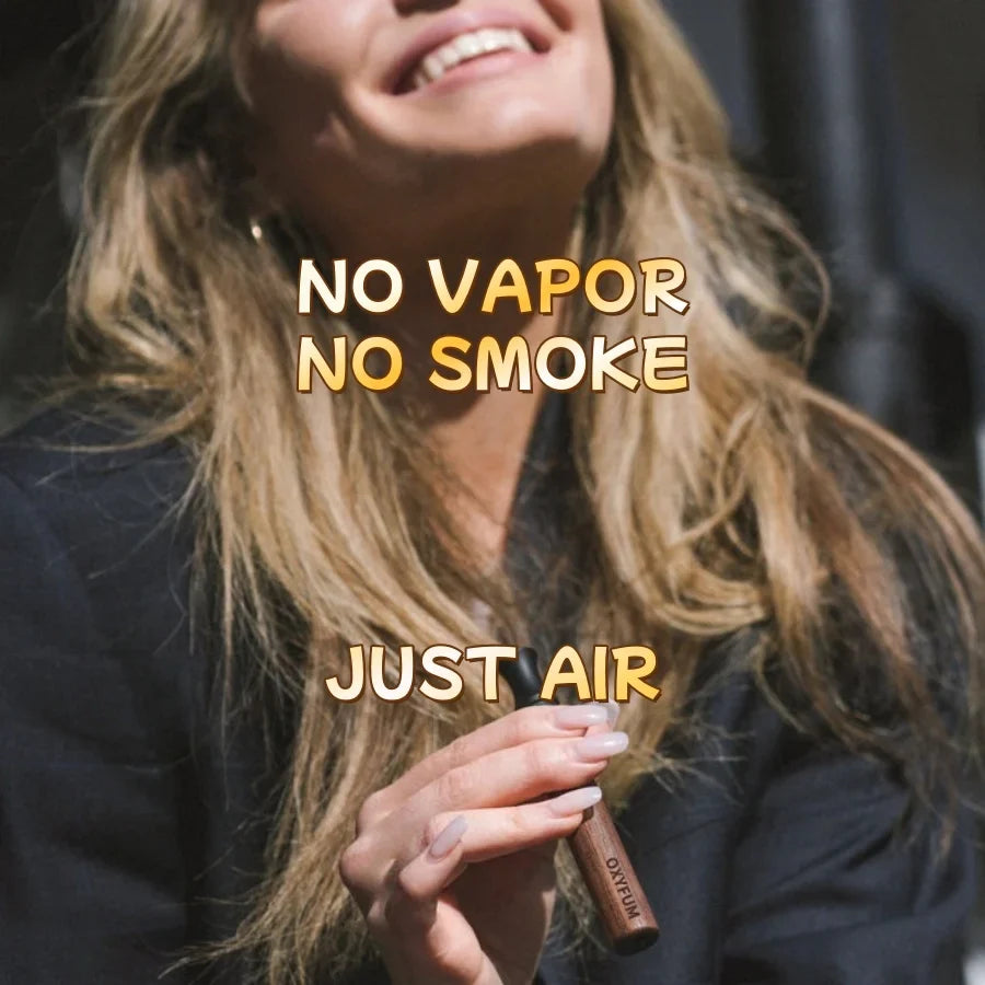 A person holding the slim wooden OXYFUM inhaler, with the words "No vapor, no smoke, just air" describing the smokeless, nicotine-free experience.