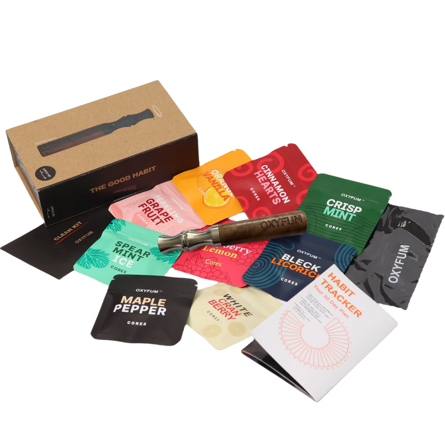 OXYFUM "The Good Habit" kit laid out: a wooden inhaler with kraft box, a clean kit cloth, a habit tracker booklet, and essential-oil flavor core packets including Grape Fruit, Orange Vanilla, Cinnamon Hearts, Crisp Mint, Spearmint Ice, Cherry, Lemon, Black Licorice, Maple Pepper and White Berry.