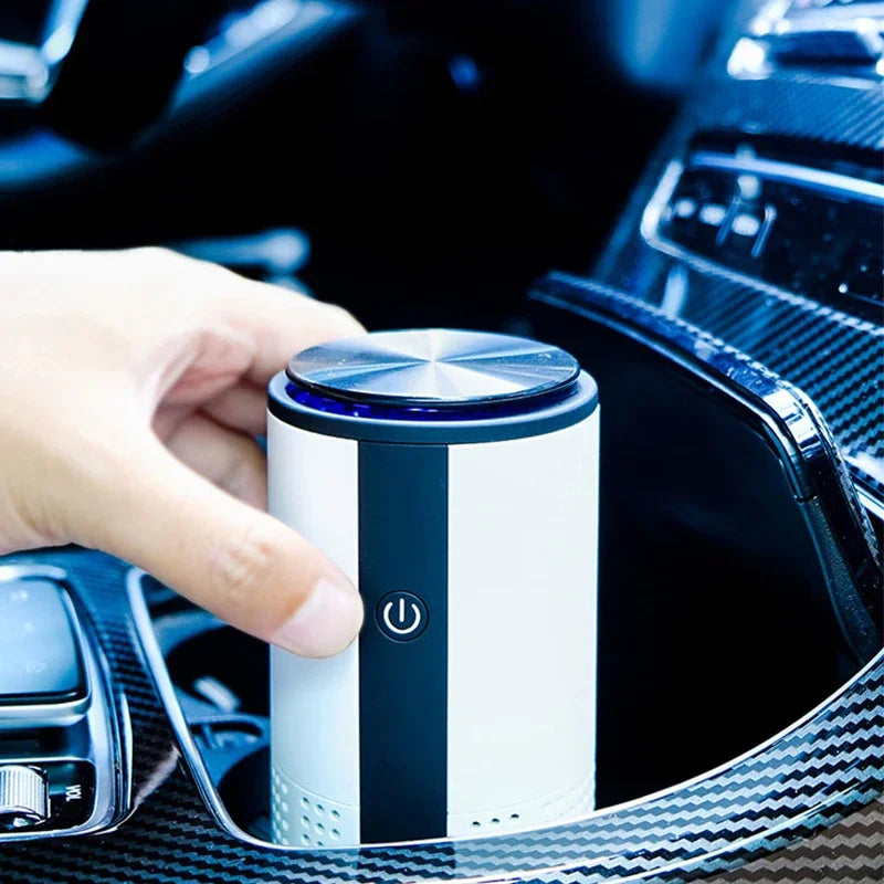 Hand lowering the compact personal car air purifier into a cup holder next to the gear shift inside a vehicle